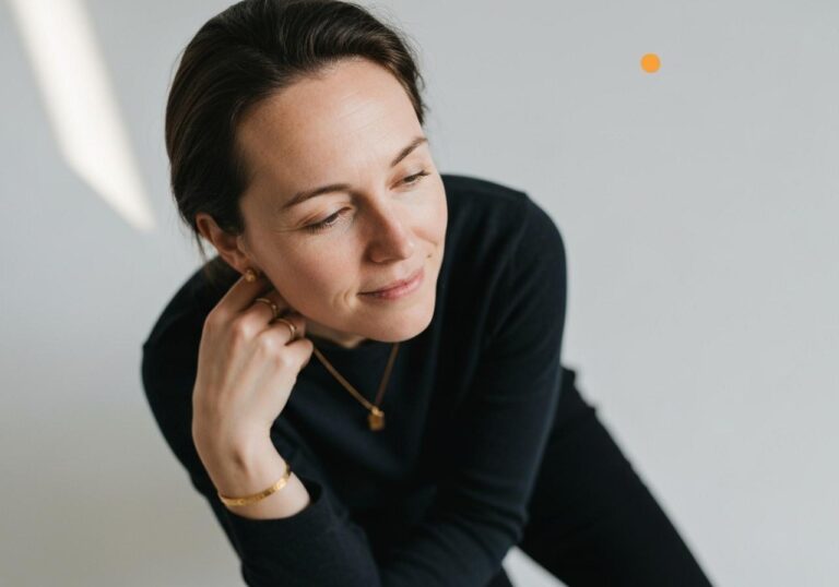 Mulher em roupa preta pensativa.